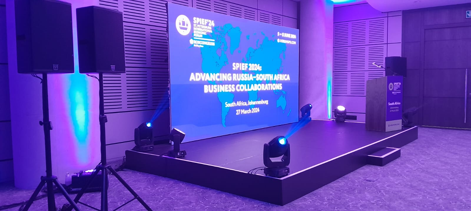 Conference stage production with branded screen and professional lighting