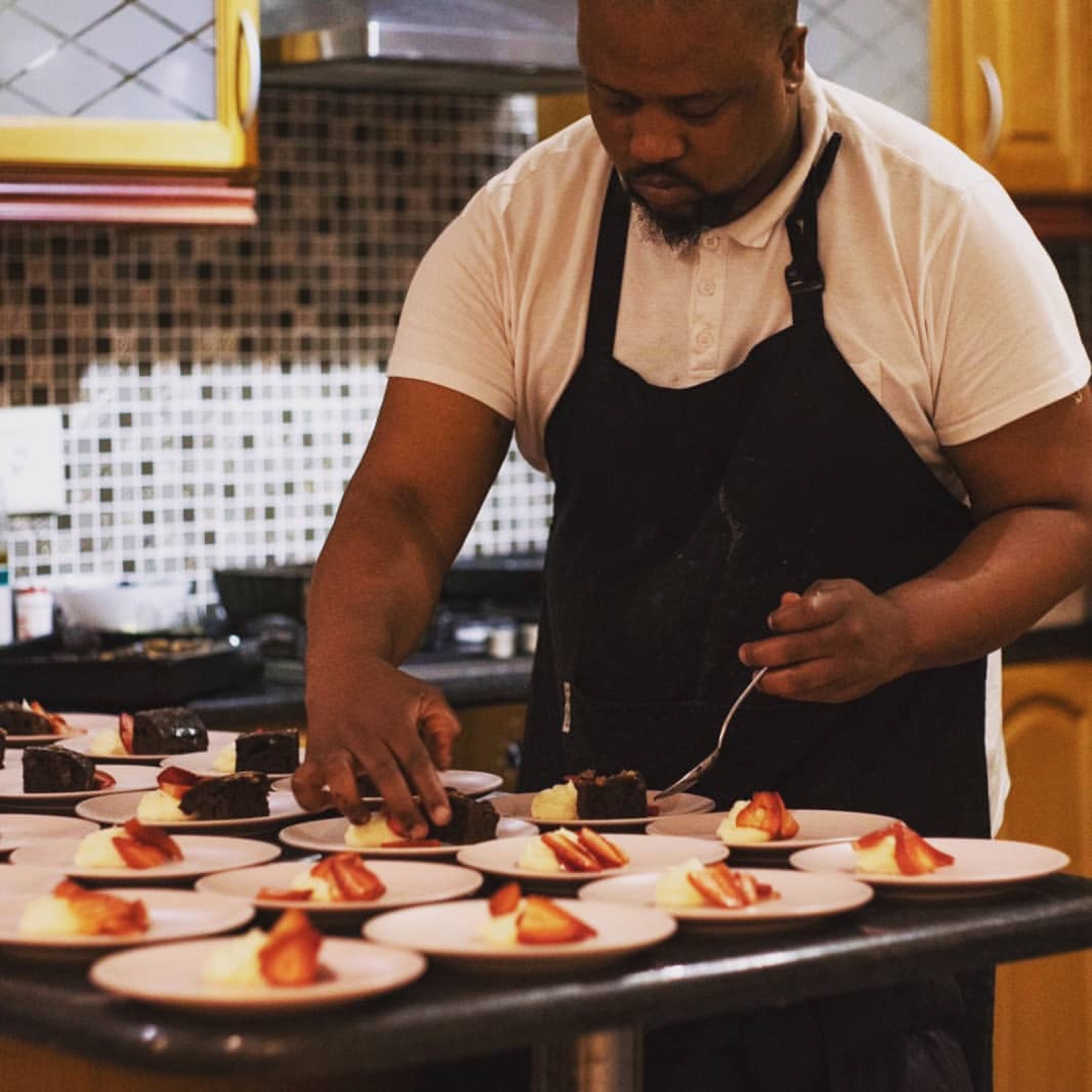 Chef plating gourmet dessert creations at a catering event